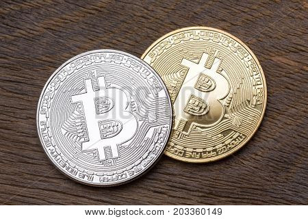 Silver and golden bitcoins on wooden background, close up. High resolution photo.