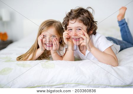 A Brother And Sister Relaxing Together In Bed