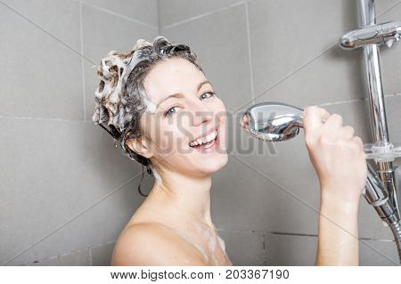 A beautiful Woman in shower washing hair with shampoo