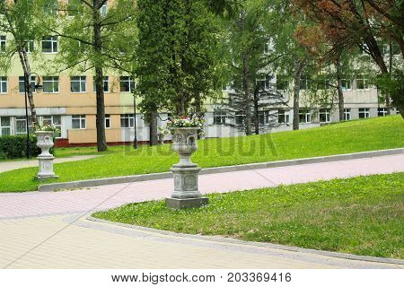 Tall gray pots in the park near the house