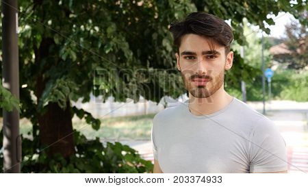 Handsome young man outdoor looking around and at camera