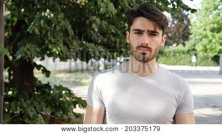 Handsome young man outdoor looking around and at camera