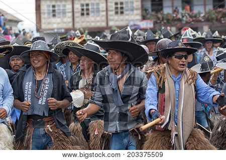 June 29 2017 Cotacachi Ecuador: kichwa men wearing a sombrero as protest against conquistadors dancing on the street during Inti Raymi festival