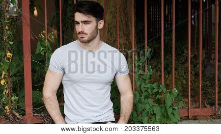 Handsome young man outdoor looking around and at camera