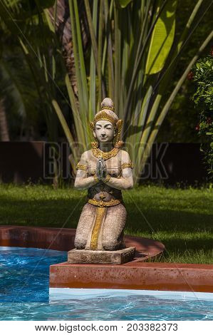 Traditional Thai sculpture near swimming pool in tropical garden. Island Koh Phangan Thailand