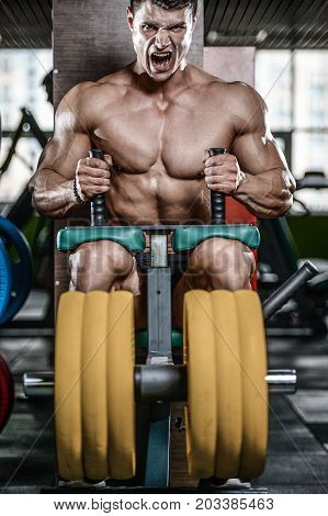 Handsome Model Young Man Training Legs In Gym