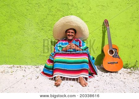 Messicano tipico argomento pigro uomo chitarra poncho sit in parete verde