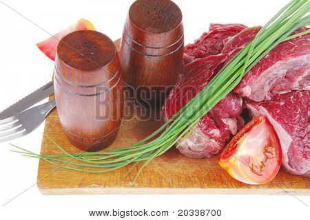 main course : fresh beef steak ready to prepare on cut board with cutlery and castor