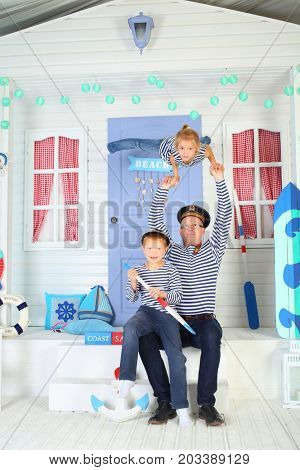 MOSCOW - OCT 04, 2016: Father (with model release) in cap  with daughter (with model release) perform acrobatic support at arms with son (with model release) on his lap on porch