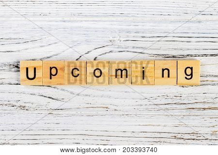 UPCOMING word made with wooden blocks concept