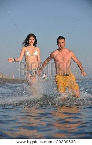 Szczęśliwa młoda para miłej zabawy i romantyczne chwile na plaży w sezonie letnim i reprezentujących happynes