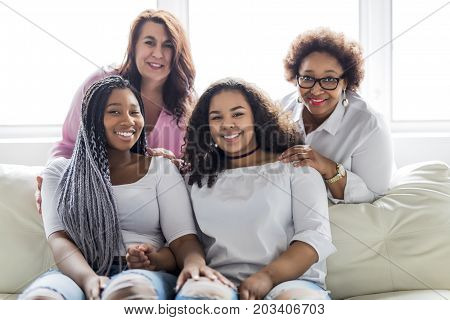 Two family Friends Sitting On Sofa Together having fun