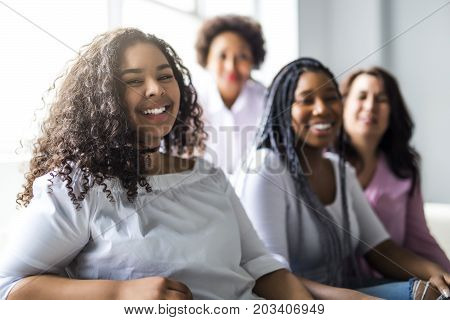 Two family Friends Sitting On Sofa Together having fun
