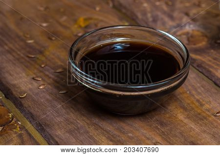 Sauce in a glass bowl on a background of a board