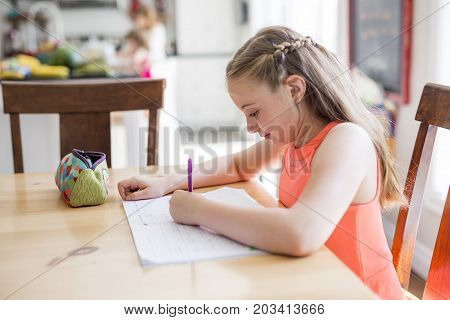A cute teen girl doing homework at home