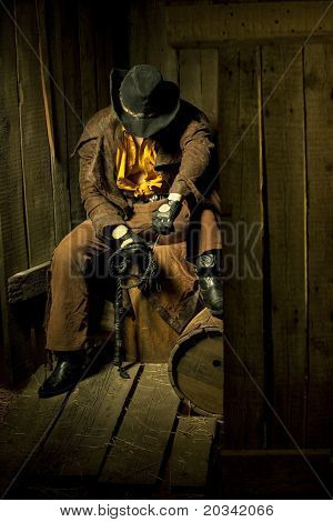 Cowboy with Black Leather Flogging Whip in his hand against wooden background