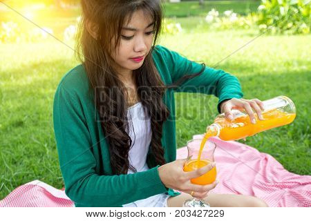 Young Woman Holding Glass Drinking Orange Juice With Friuits Basket. Top View From Back. Healthy Con