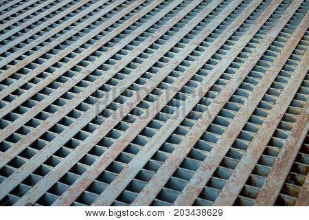 Vintage grille sewage pipe with rust for cover the drain on concrete road or street.