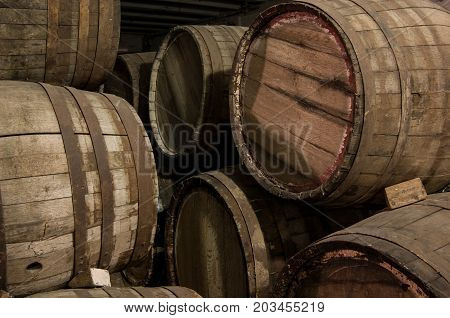 closeup of some wooden wine barrels in cellar