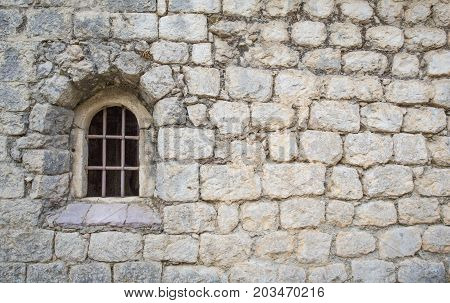 window with a bar in the old church. Masonry walls.