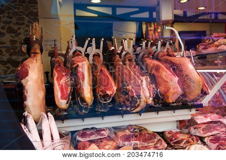 CAMBRILS, SPAIN - AUG 27th, 2017: Spanish ham on a market, jamon iberico in view black leg pork isolated, traditional national spain meat in store, serrano prosciutto food on background gastronomy, bacon berian on cuisine.