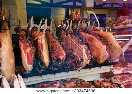 CAMBRILS, SPAIN - AUG 27th, 2017: Spanish ham on a market, jamon iberico in view black leg pork isolated, traditional national spain meat in store, serrano prosciutto food on background gastronomy, bacon berian on cuisine.