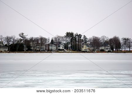 A view of Harbor Point homes, across ice-covered Little Traverse Bay, as seen from the beach in Wequetonsing, Michigan, during March.