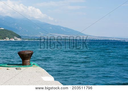 Dock Cleats On A Pier To Tie-up Boats With Blue Sea As The Background