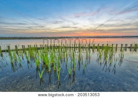 Sunset Over Lake With Shore Protection And Riparian Zone