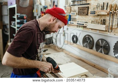 Young Professional Carpenter Working In The Workshop
