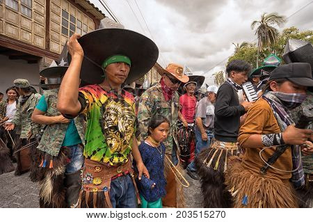 June 24 2017 Cotacachi Ecuador: indigenous kichwa people wearing chaps dancing in the crowd at the Inti Raymi parade at summer solstice
