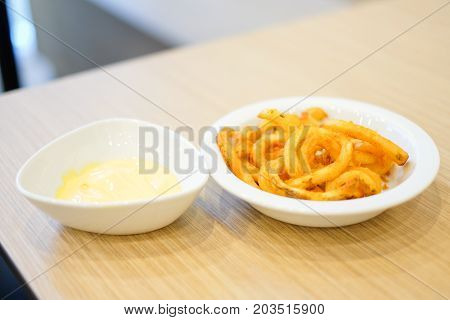 French fries with hot cheese dip sauce recipe serve on white plate for food background or texture - Fast Food concept.