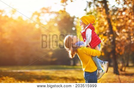 happy family mother and child daughter playing and laughing on autumn walk