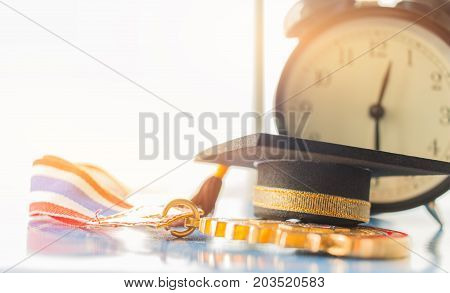 Graduation cap on Golden medals with clock graduate education in university Competitions and Educational study concepts. Success in study famous institution Concept of winner abroad international.