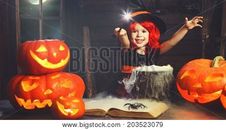 Halloween. little witch child cooking potion in the cauldron with pumpkin and spell book