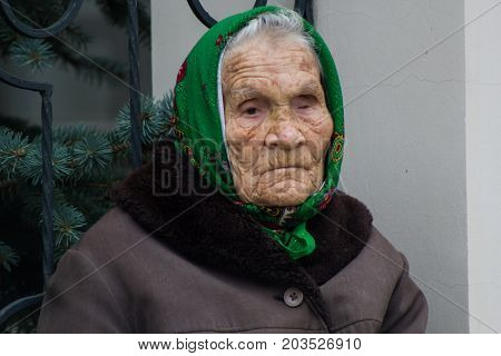 KAZAN, RUSSIA - September 5, 2017: Elderly grandmother with defect of vision near Orthodox Church, telephoto shot
