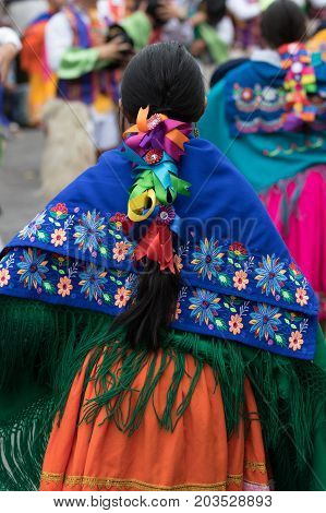 June 17 2017 Pujili Ecuador: closeup detaisl of a kichwa indigenous woman dancing in a colourful traditional dress at Corpus Christi parade