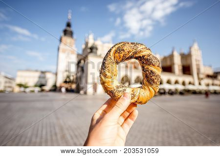 Holding prezel, traditional polish snack on the Market square in Krakow