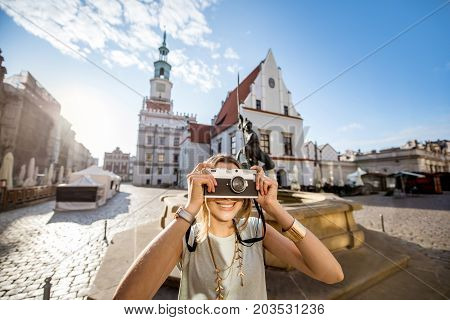 Porait of a young woman tourist traveling on the old Market sqaure in Poznan city during the morning light in Poland