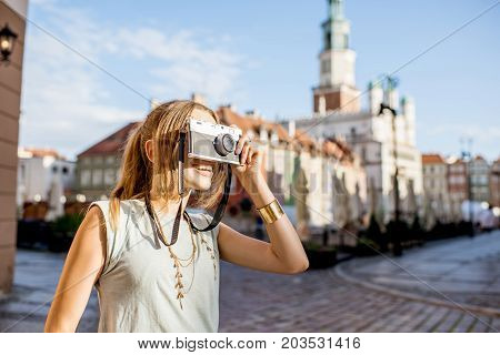 Porait of a young woman tourist traveling on the old Market sqaure in Poznan city during the morning light in Poland