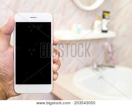 Human hand holding wet smart phone in water closet with copy space. Water damage waterproof concept.