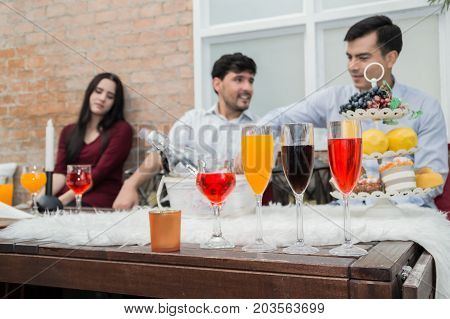 Young people holding glass talk in the party.