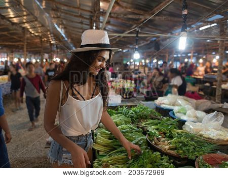 Young Woman Choosing Green Potherbs On Market Girl Shopping On Traditional Street Bazaar