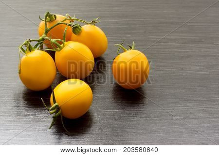 Fresh yellow tomatoes close up on wooden table. Top view