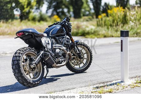 Cool looking custom made scrambler style cafe racer standing on road