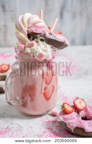 Pink strawberry freakshake milkshake with sweets donut and marshmallow