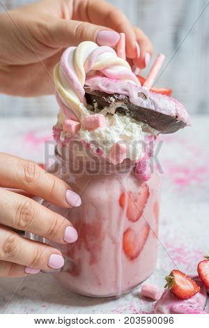 Pink strawberry freakshake milkshake with sweets donut and marshmallow
