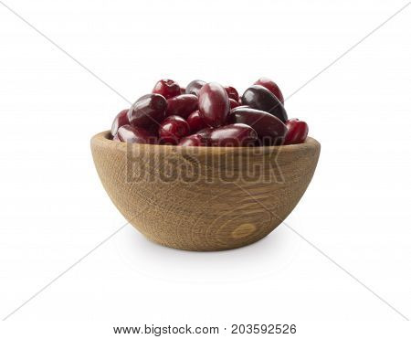 Cornels isolated on a white background. Cornels in a bowl with copy space for text. Ripe cornel close-up. Background berry.