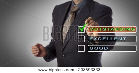 Unrecognizable male corporate manager is checking the tick box next to the label OUTSTANDING followed by unchecked EXCELLENT and GOOD. Business concept for performance review and HR management.