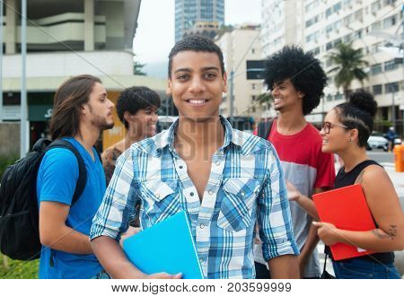 Happy hipster male student with group of multi ethnic young adults outdoor in city